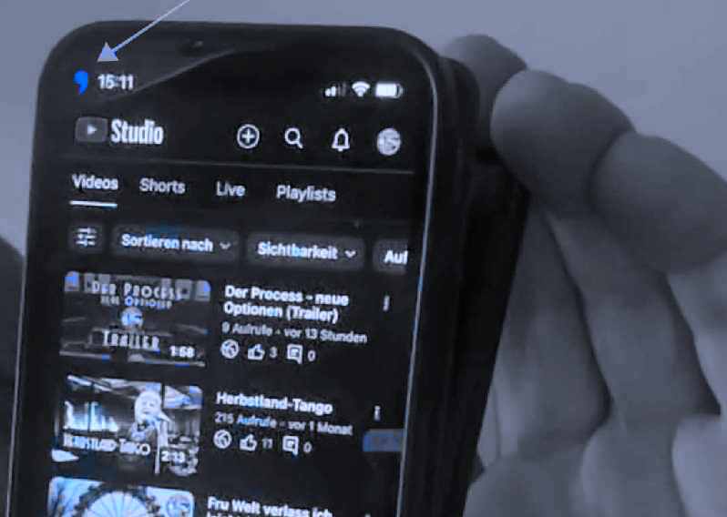 zeigt Handy mit dem rätselhaften blauem Apostroph links oben