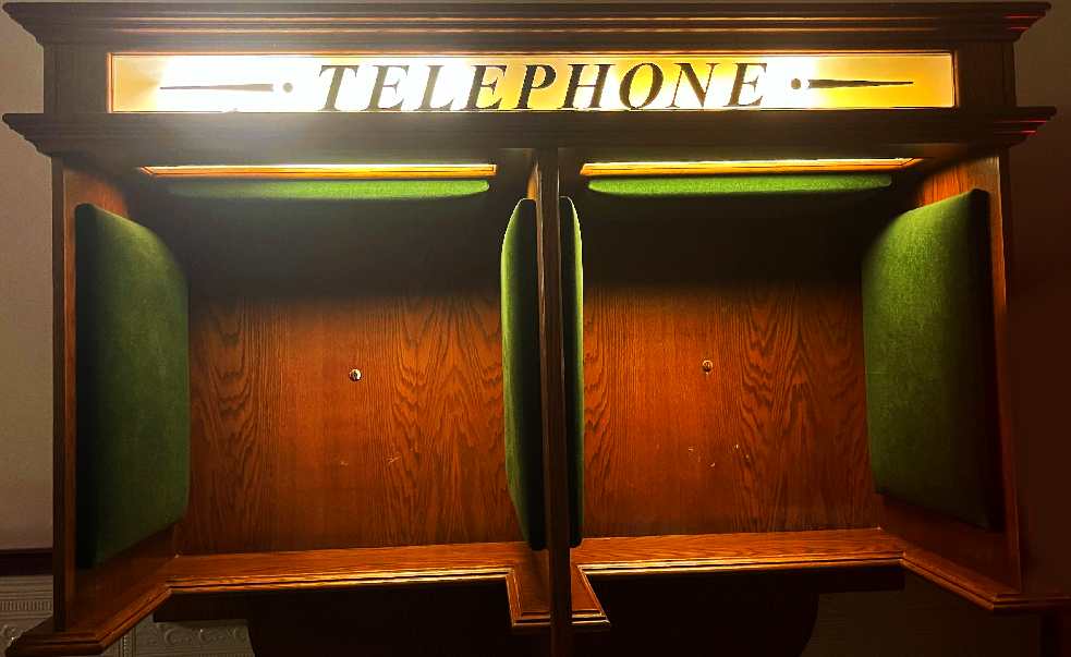 Zeigt eine leere Telephonzelle, aufgenommen in einem alten Hotel in Breda/Niederlande